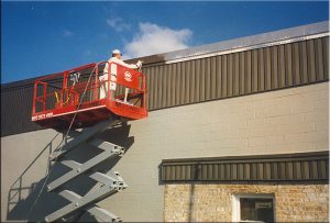 Spraying building from lift in Highlands Ranch